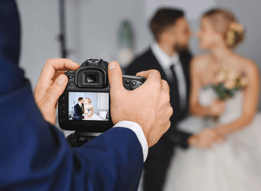 A photographer capturing a couple on their wedding day, reflecting The Ultimate Vegan Gentleman’s Wedding Wardrobe.