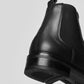 Vegan Chelsea boots - Woman showing the back angle with sleek black design and sturdy heel.