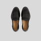 Vegan Loafer - Man in sleek black design with distinctive stitching and comfortable fit from above view.