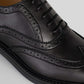 Vegan Oxford Brogue - Woman close-up showing broguing details and sleek black finish.