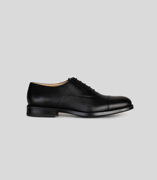 Vegan Oxford - Man side view of formal black shoes with rounded toe and laces, showcasing sophisticated style.