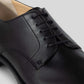Close-up of a black Vegan Derby - Man shoe featuring an open lacing system and Blake Construction.