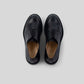 Vegan Derby - Woman in black leather, featuring an open lacing system, perfect for formal and casual events.